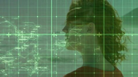 Woman studying technical schematics in tech lab, with green grid overlay showing Video stock 309096835