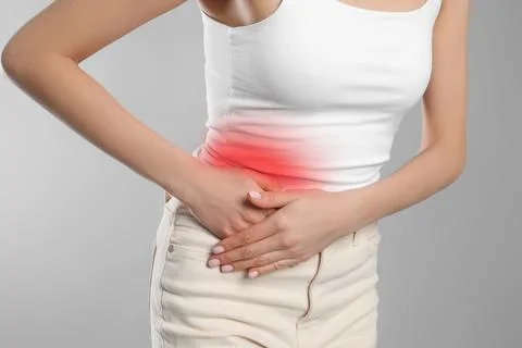 Woman suffering from appendicitis inflammation on grey background, closeup Stock Photos