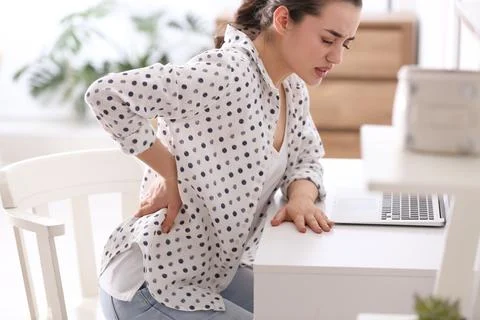 Woman suffering from back pain in office. Bad posture problem Stock Photos