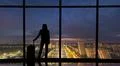 The woman with suitcase stands near the windows in the business office buildi Photo