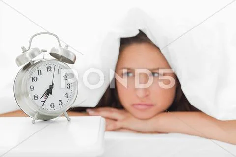 Woman sulking under her duvet Stock Photos