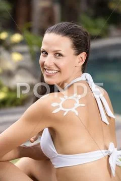 Woman With Sun Cream In Shape Of Sun On Shoulder