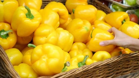 A woman in a supermarket on a vegetable shelf, buys vegetables and fruits. Man Stock Footage