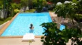 Woman Swimming in Blue Outdoor Swimming Pool. Beautiful Summer Landscape. HD Footage