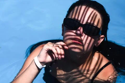 Woman in swimming pool with dramatic shadow patterns, Stock Photos