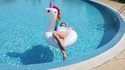 Woman in swimsuit on inflatable pool float in pool in the hotel. Summer holi Stock Footage 268448879