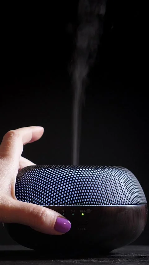 Woman switch on Diffuser for essential oils on black background. Vertical Stock Footage 311062849