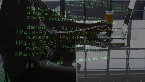 Woman at table by large window typing on laptop, coding, causing green code Stock Footage 326974467