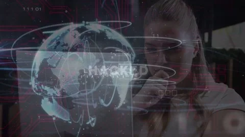 Woman at table responding to HACKED alert on laptop while tech HUD globe red Stock Footage 333477622