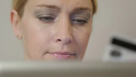 Woman with tablet computer makes a payment by credit card at home Video stock 70359642