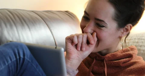 Woman tablet couch - laughing Video stock 132061453