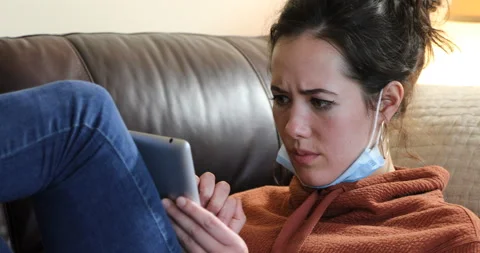 Woman tablet couch mask down - concerned 2 Video stock 132068232