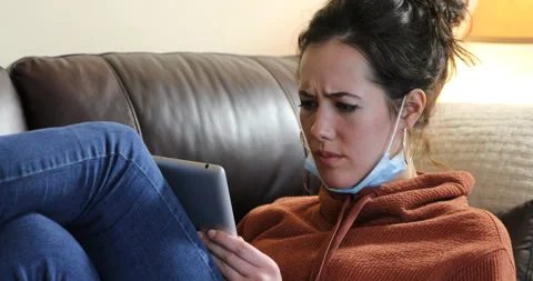 Woman tablet couch mask down - upset Video stock 132076705