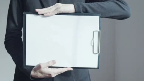 A woman with a tablet in her hands on which a white sheet of paper is attached. Stock Footage 232998341