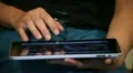 A woman with tablet on legs (close-up) HD Footage