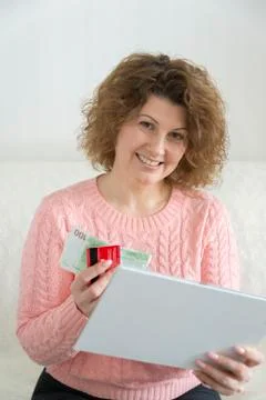 Woman with tablet pc computer and credit card, money at home Stock Photos