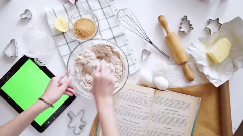 Woman with tablet pc computer making gingerbread houses at home Stock Footage 58819568