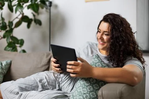 Woman with tablet pc computer on sofa at home Stock Photos