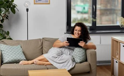 Woman with tablet pc computer on sofa at home Stock Photos