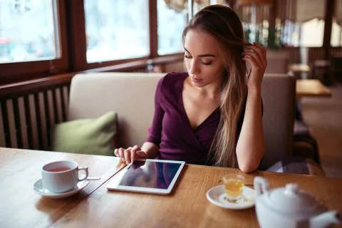 Woman with tablet pc using internet in restaurant. Stock Photos