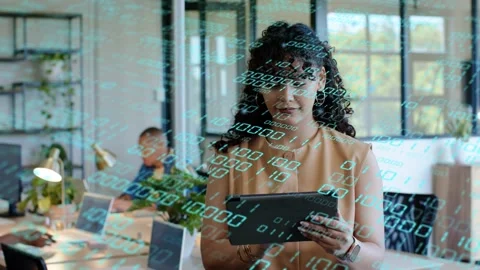 Woman with tablet tapping and causing teal binary overlay growing over office Stock Footage 334338078