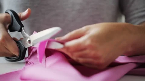 Woman with tailor scissors cutting out fabric Stock Footage