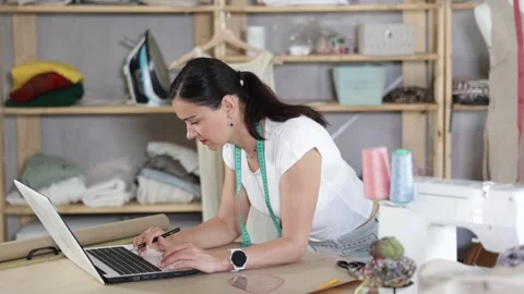 Woman tailor uses computer when creating drawing of future product Stock Footage 313100017