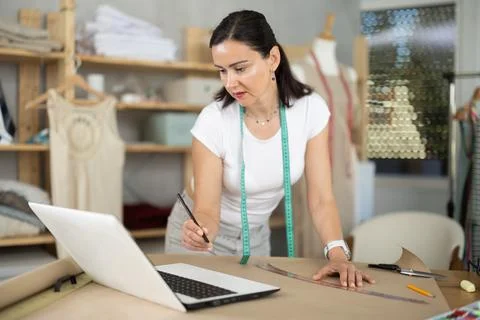 Woman tailor uses computer when creating drawing of future product Stockfoto's