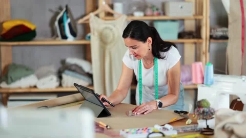 Woman tailor uses tablet when creating drawing of future product Stock Footage 313457284