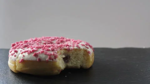 Woman takes a donut missing a bite and eats it 스톡 동영상 99045434