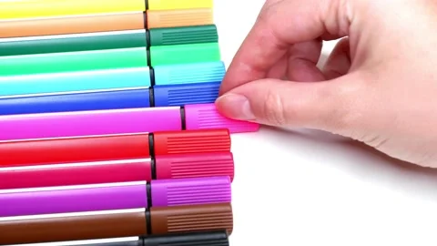 The woman takes a pink marker from a stack of colored markers. Stock Footage 157642697