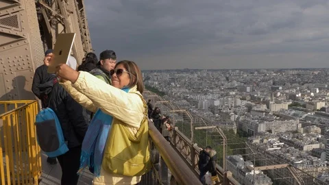 Woman takes selfie using a tablet on top of the Eiffel Tower, Paris SLOW Vidéo 112073620