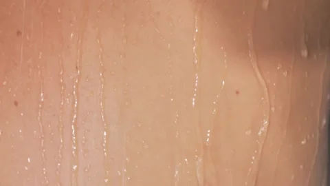 A woman takes a shower at a slow pace. beautiful girl washes and has fun in the Stock Footage 220369704