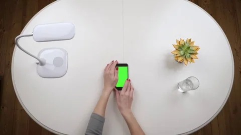 Woman takes a smartphone an typing using app. Chroma key. Top view. Hands close Stock Footage 84882959