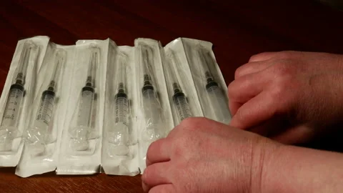 A woman takes a syringe in a white box. Close-up Stock Footage