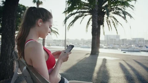 Woman taking a break checking her train programme and schedule on smartphone app Stock-Footage 100420832
