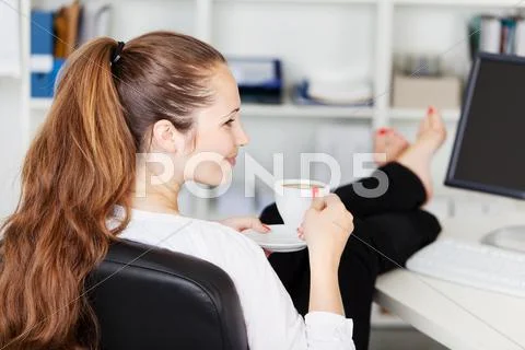 Woman taking a coffee break in her office Stock Photos