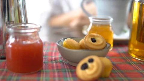 Woman taking cookie while drinking tea, close up. Tea pot, honey, jam, cakes. Stock Footage 88663611