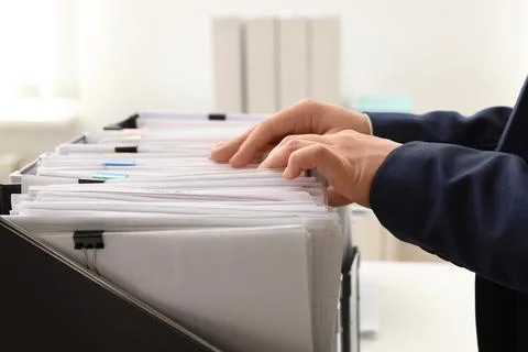 Woman taking documents from folder in archive, closeup Stockfoto's