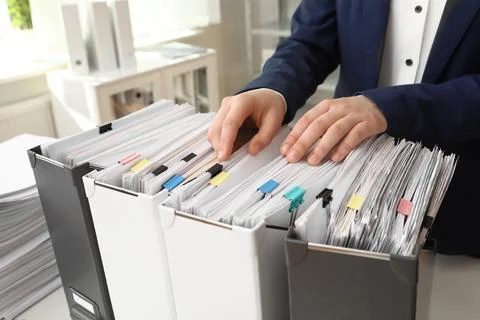 Woman taking documents from folder in archive, closeup Stockfoto's