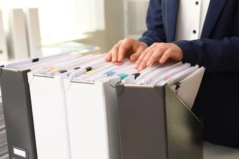 Woman taking documents from folder in archive, closeup Stockfoto's