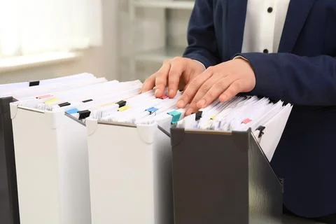 Woman taking documents from folder in archive, closeup Stockfoto's