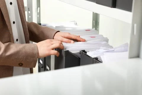Woman taking documents from folder in archive, closeup Stockfoto's