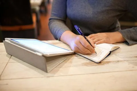 Woman taking down information in notebook Stock Photos