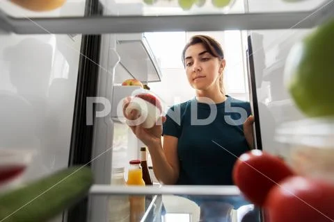 Woman taking food from fridge at home Stock Photos