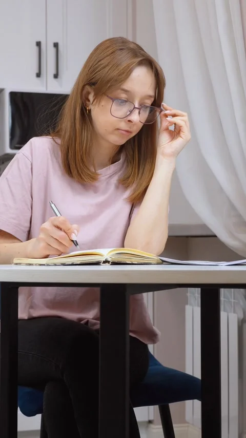 Woman taking notes from documents at home Stock Footage 314610312