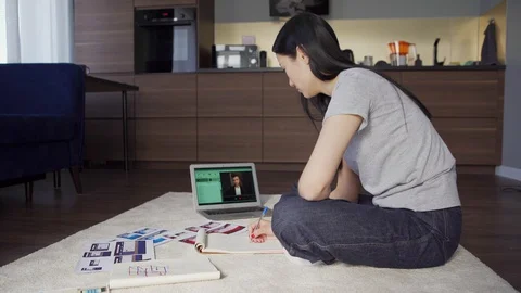 Woman taking notes during video call with manager Stock Footage 128751116