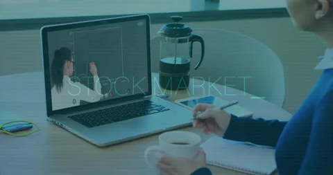 Woman taking notes in home office, watching stock tutorial on laptop with 動画素材 307448071