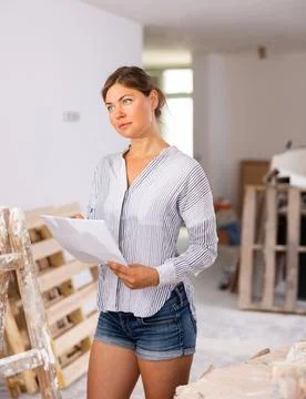 Woman taking notes while planning upcoming home overhaul Stock Photos
