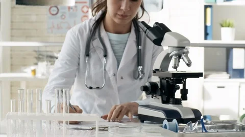 Woman Taking Notes while Studying Samples Stock Footage 95686318